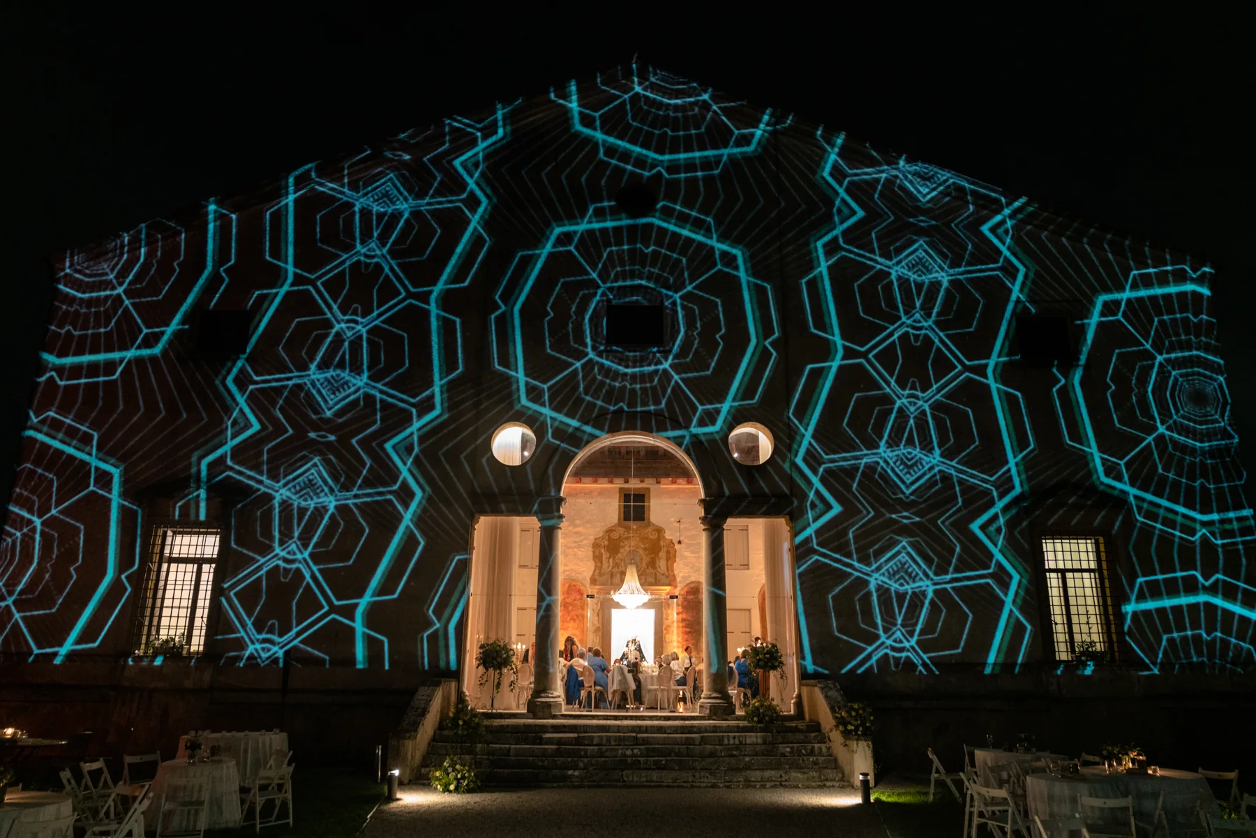 Facciata della villa illuminata da proiezioni colorate durante un evento