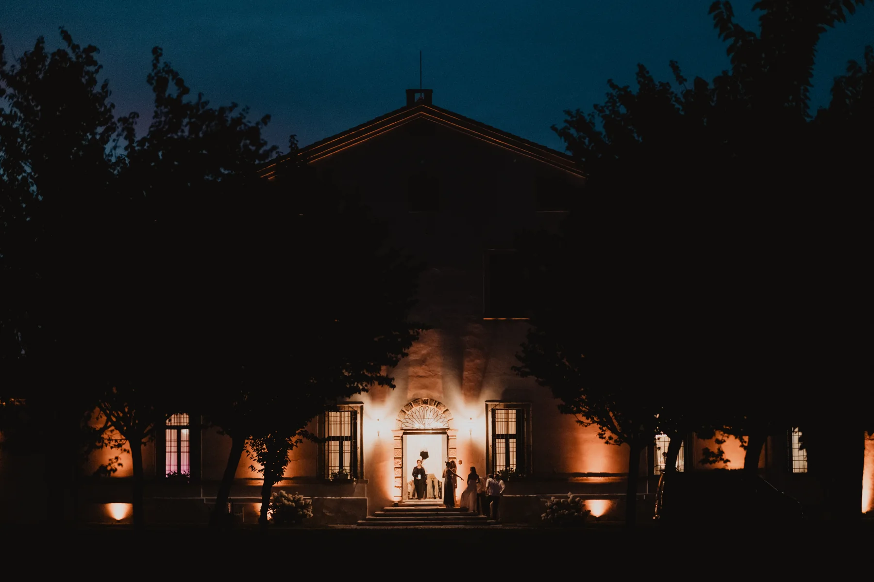 Facciata e ingresso della villa illuminati di notte