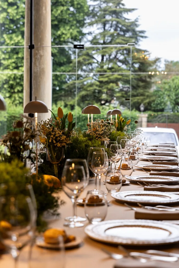 Tavola apparecchiata con fiori sotto la loggia affacciata sul verde